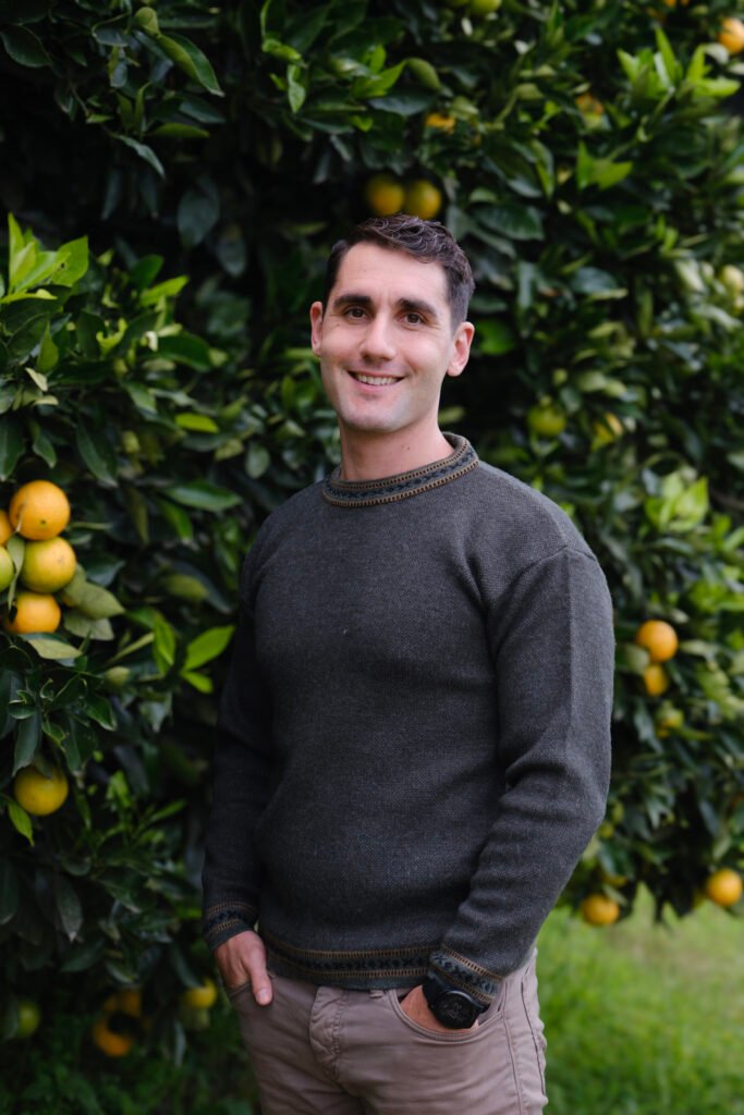 Simon Erlich, IFS therapist in Ontario, standing by an orange tree with a warm and approachable presence